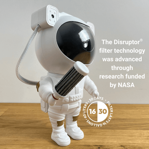 Astronaut toy holding Flavafil MAX water filter with text about Disruptor filter technology and NASA funding on a wooden surface.