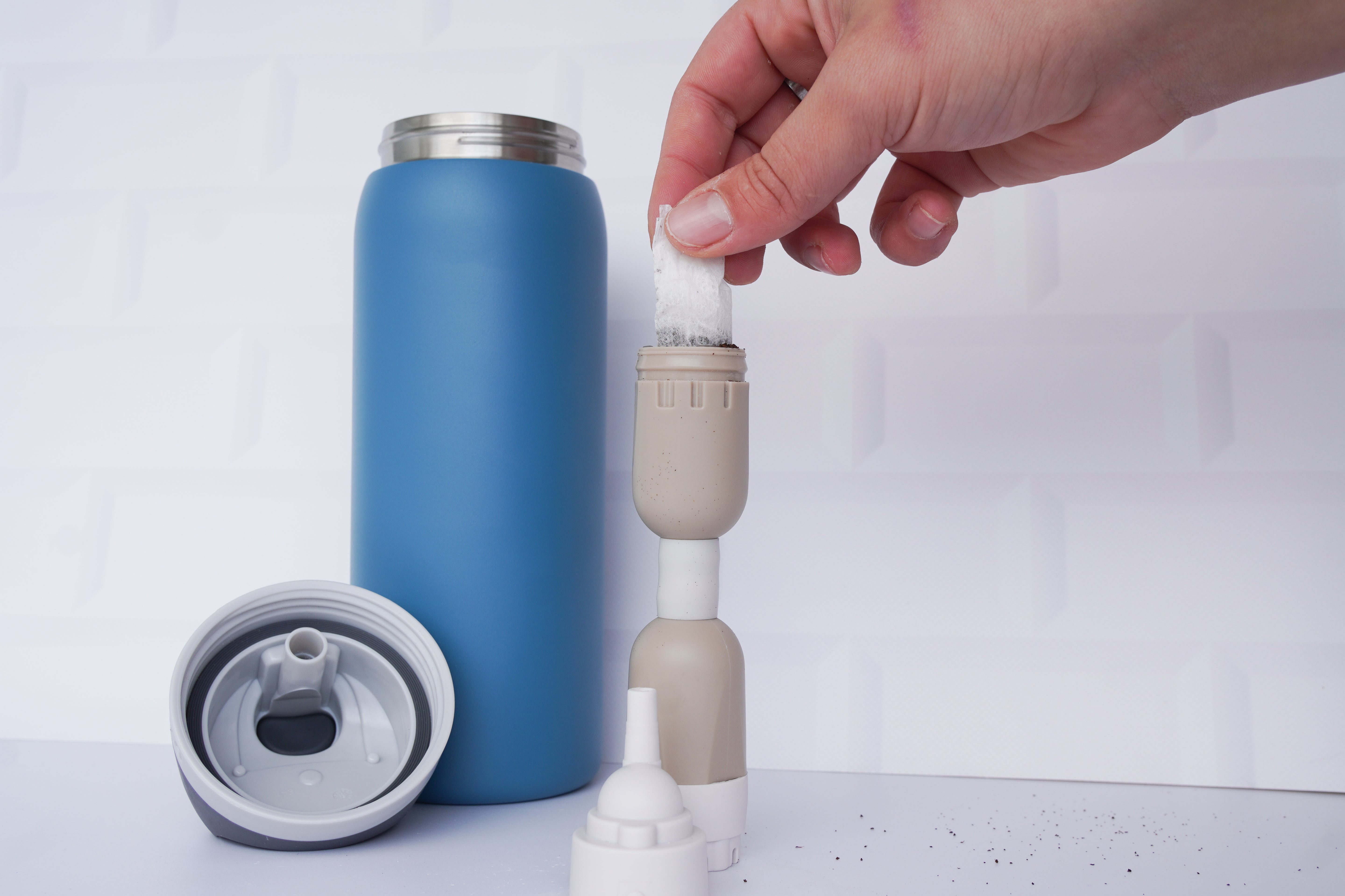 Cold brew tea bag being placed into the FlavaFil FlavaBullet flavor chamber to infuse water with tea without leaving residue in the bottle.
