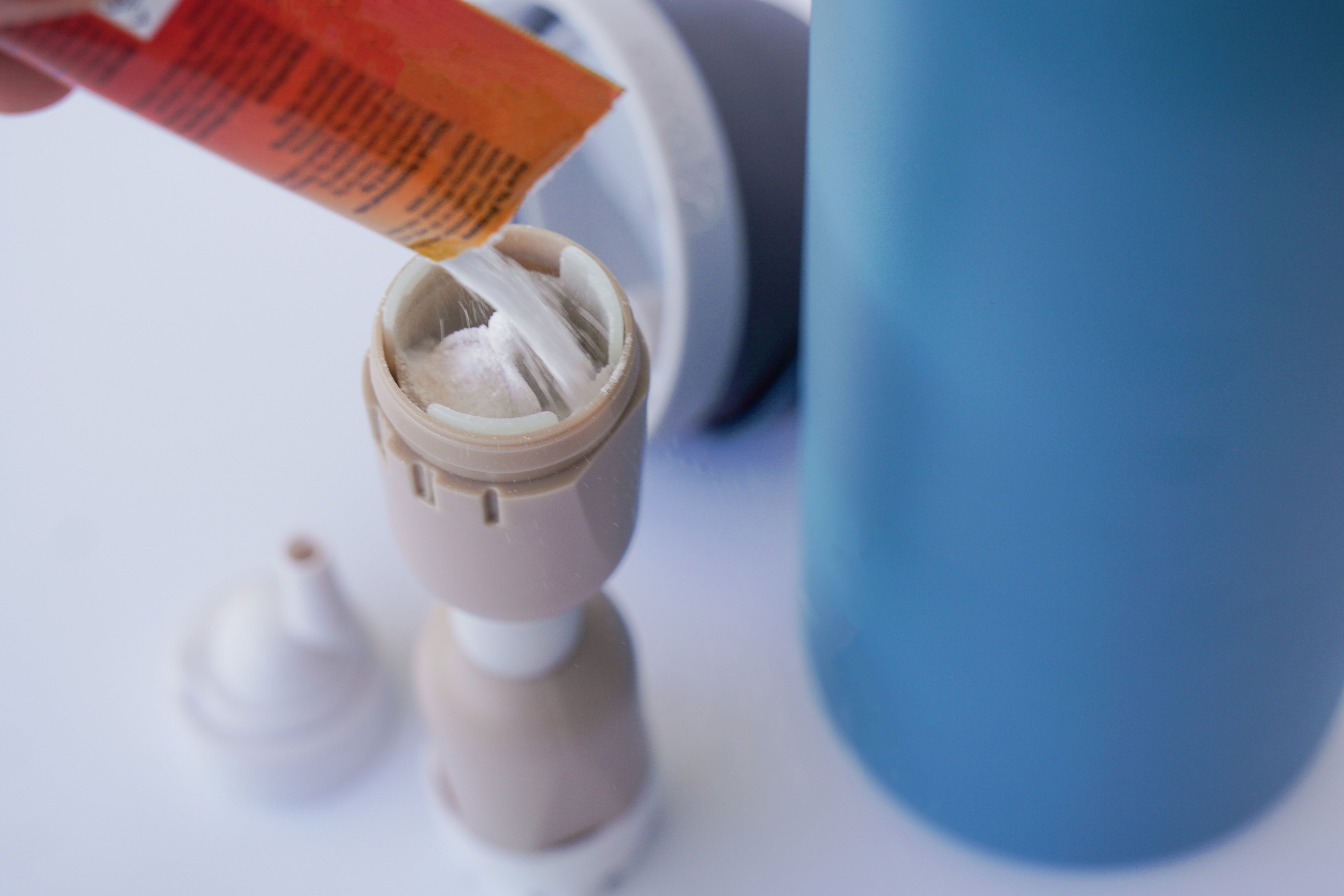 Electrolyte powder being poured into the FlavaFil FlavaBullet flavor chamber to add hydration mix to water without clogging or residue