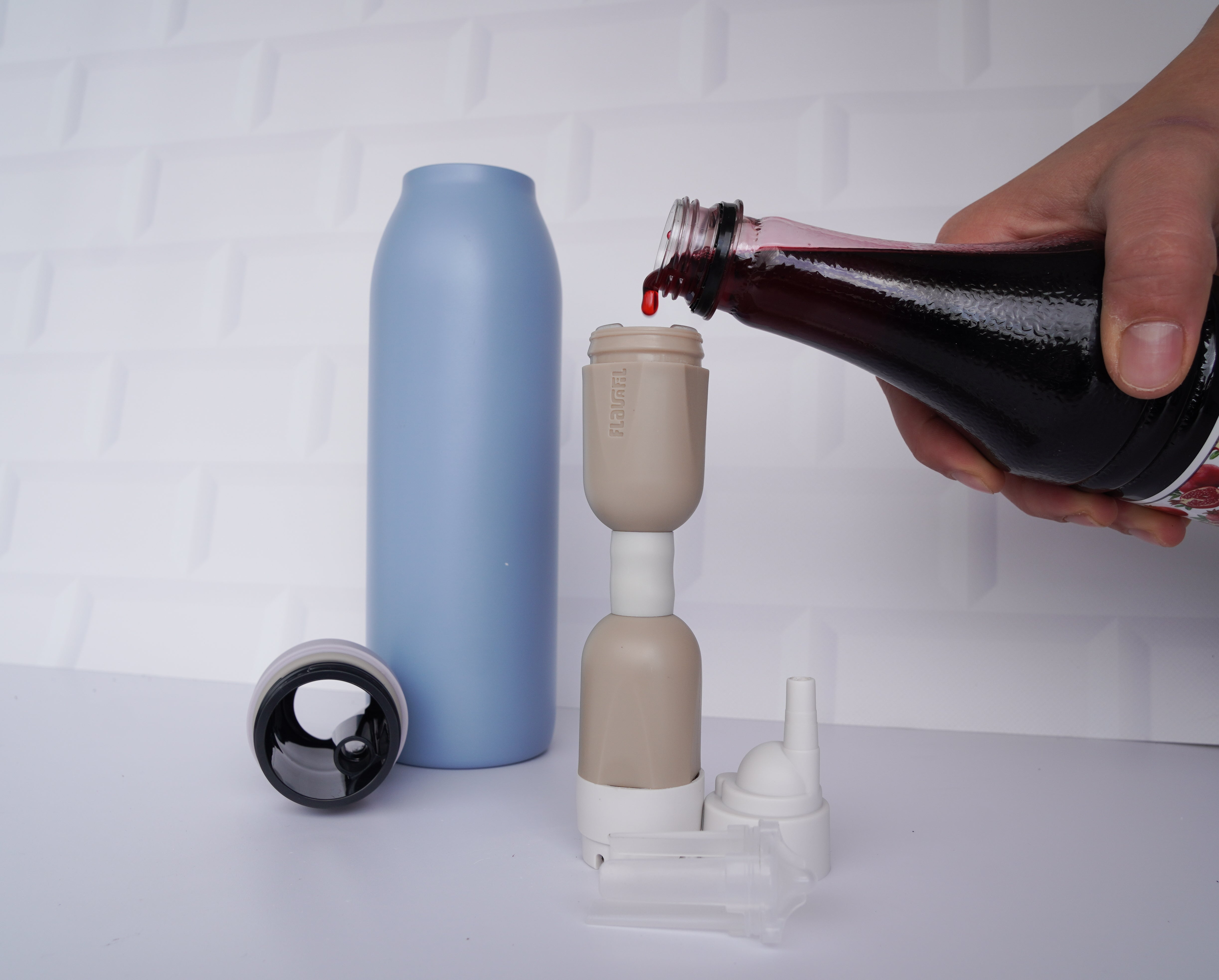 Flavor syrup being poured into the FlavaFil FlavaBullet to add sweetness and taste to water without mixing directly into the bottle.